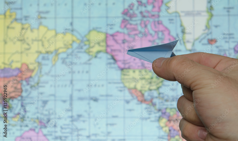 Obraz premium paper airplane on a background map of the world