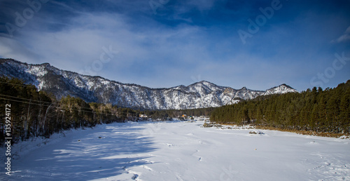 Magnificent views of the mountainous terrain in the winter with a frozen river