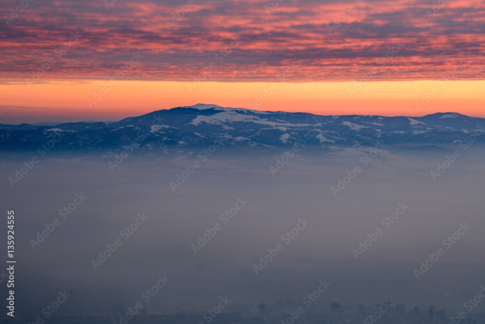 Fiery skies above the morning mist - beautiful winter landscape on a mountain top