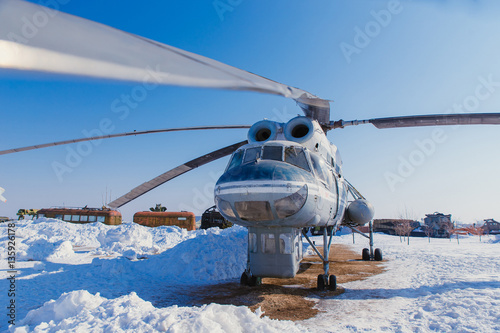 A large helicopter on the ground in winter