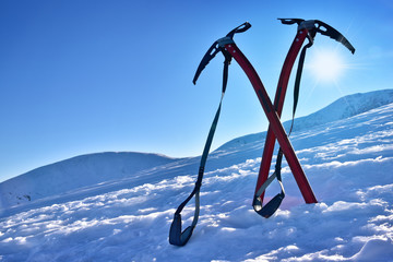 Canvas schilderij Alpinisme Twee ijsbijlen op besneeuwde berghelling  © aboutfoto