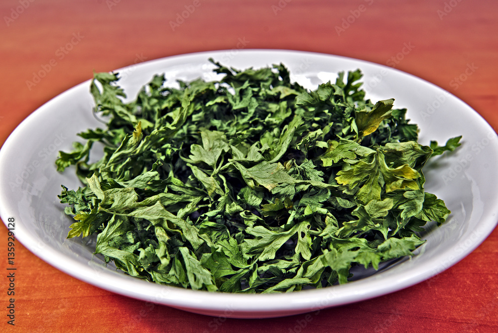 Dried parsley in a white plastic bowl Dried parsley in a white plastic bowl