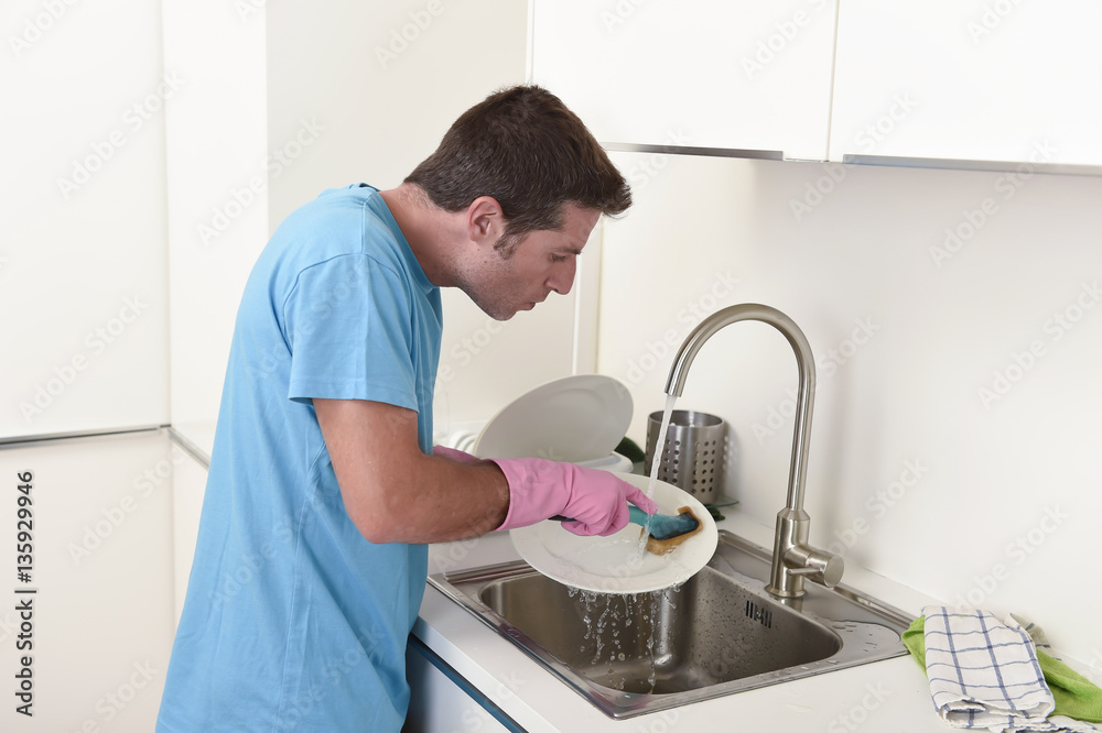 young house cleaner man washing the dishes and cleaning the kitchen in stress and desperate young house cleaner man washing the dishes and cleaning the kitchen in stress and desperate