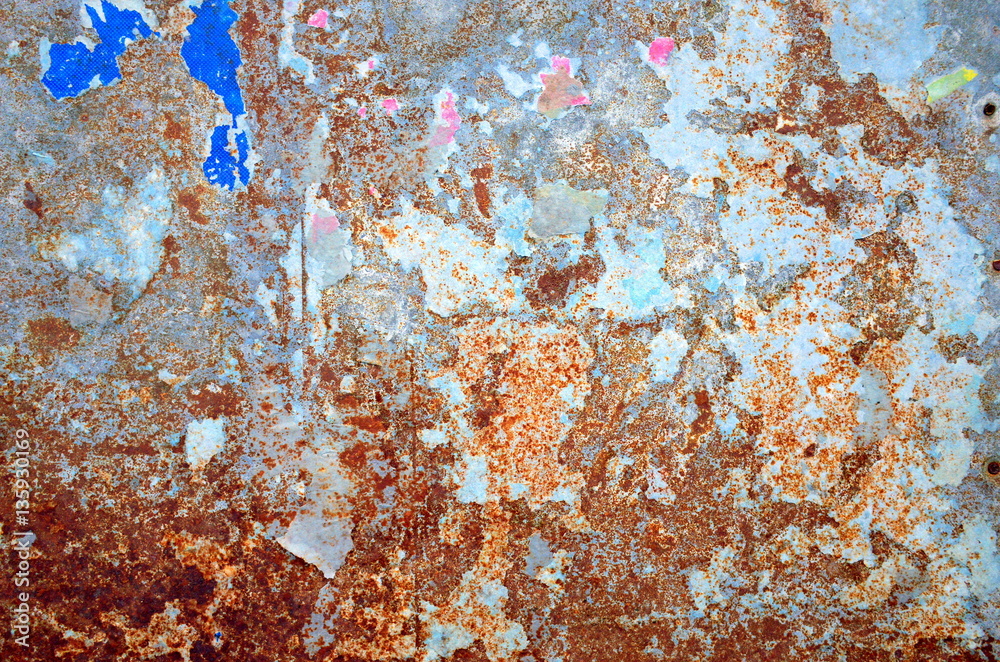 A background of torn scraps and paper and rusty metal after a poster is removed from a billboard