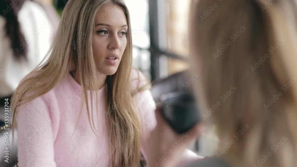 Two women friends speaking in a cafe Two women friends speaking in a cafe