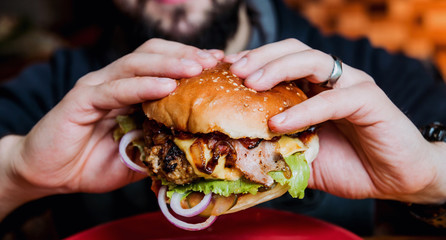 Young man eating a cheeseburger.
