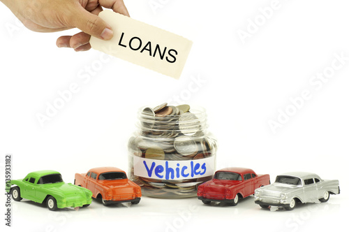 hand holding lons sign over money coins and toy car isolated on white background photo