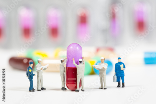 miniature people on the drugs or pils on white,medical concept photo