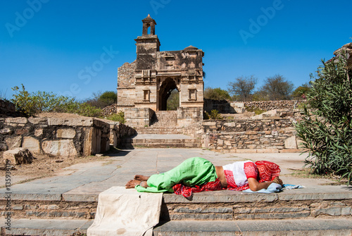 Chittorgarh Fort, the largest fort in India;. Woman sleeping near the ruins of Hindu Temple photo