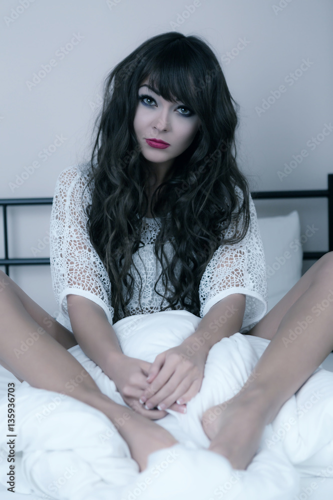 Naklejka premium attractive brunette woman on a bed