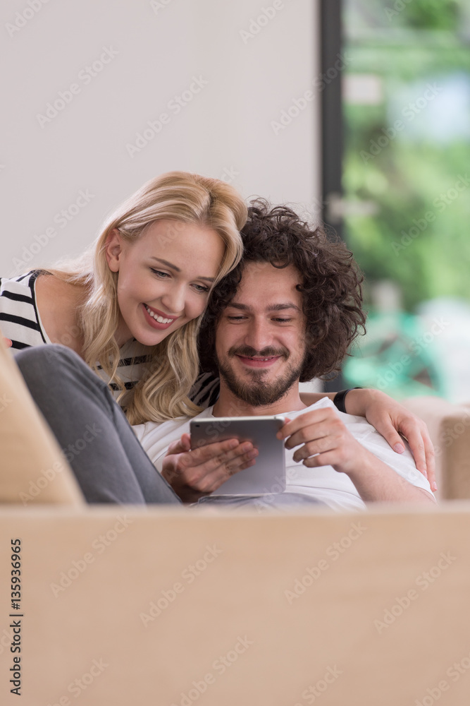 couple relaxing at home with tablet computers couple relaxing at home with tablet computers
