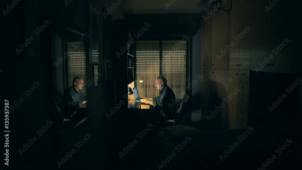 Old man chatting with computer in his bedroom Old man chatting with computer in his bedroom