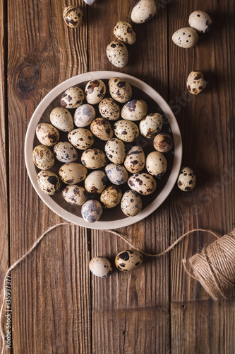 Quail eggs in a brown plate on a wooden table. Rustic Style. Eggs. Easter photo concept. Copyspace