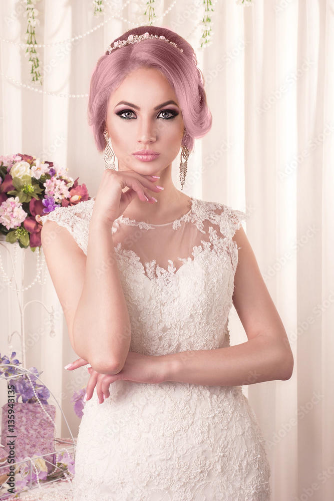 The beautiful woman posing in a wedding dress. Beautiful bride with makeup and hairstyle. The beautiful woman posing in a wedding dress. Beautiful bride with makeup and hairstyle.