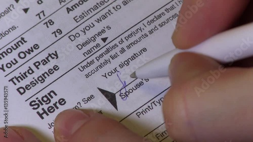 Female Hands Putting Signature To The US Individual Income Tax Return Form 1040