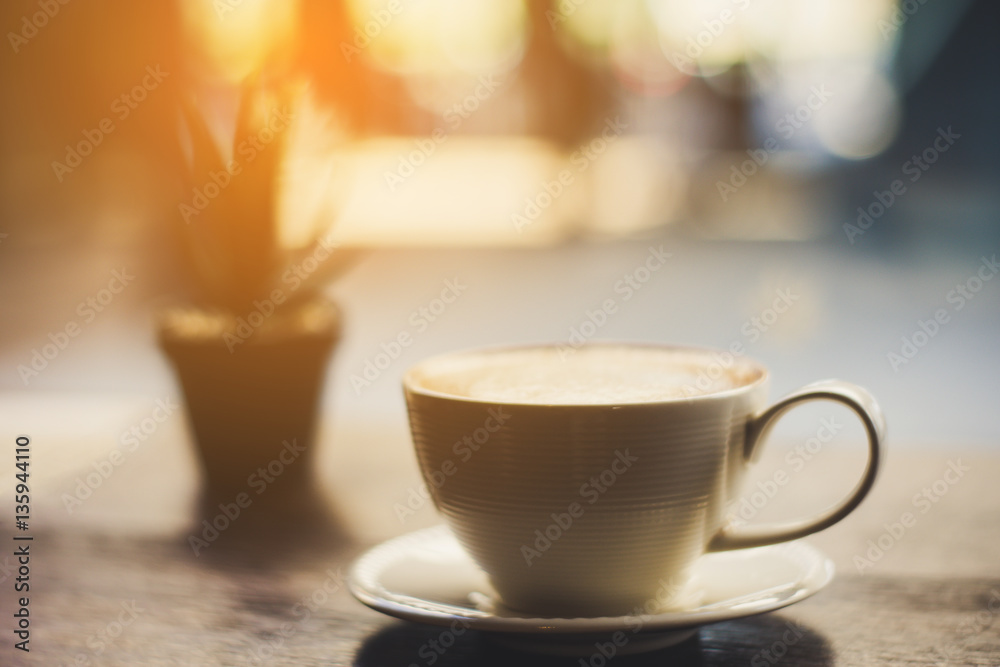 Obraz premium coffee with plant on the wood table at the sunrise
