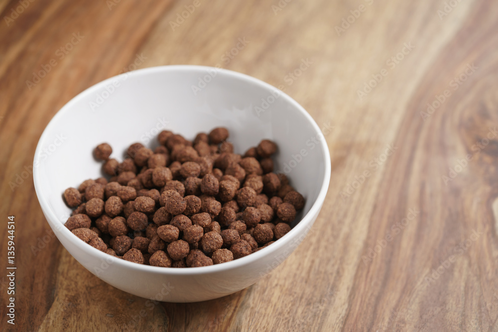 chocolate cereal balls in white bowl for breakfast, shallow focus chocolate cereal balls in white bowl for breakfast, shallow focus