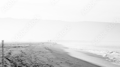 Beach scene in black and white with mist and people