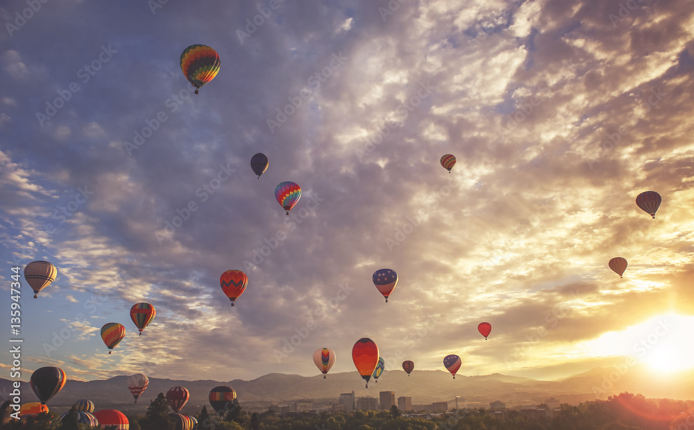 Naklejka premium hot air balloons in the sky during sunrise toned with a retro vi