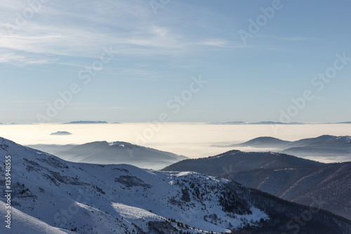 Winter mountains in the clouds in daylight at a ski resort