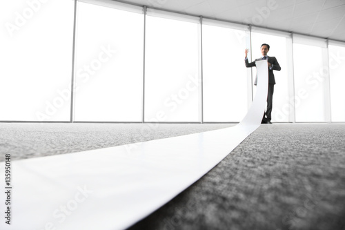 Office worker unrolling long sheet