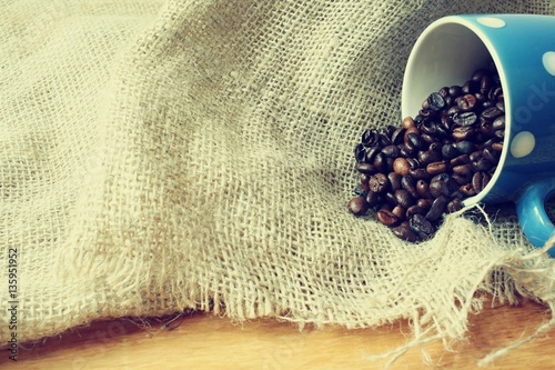 roasted coffee beans in a cup and wood background bags