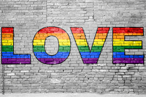 Ziegelsteinmauer mit Gay Love Regenbogenfahne Graffiti
