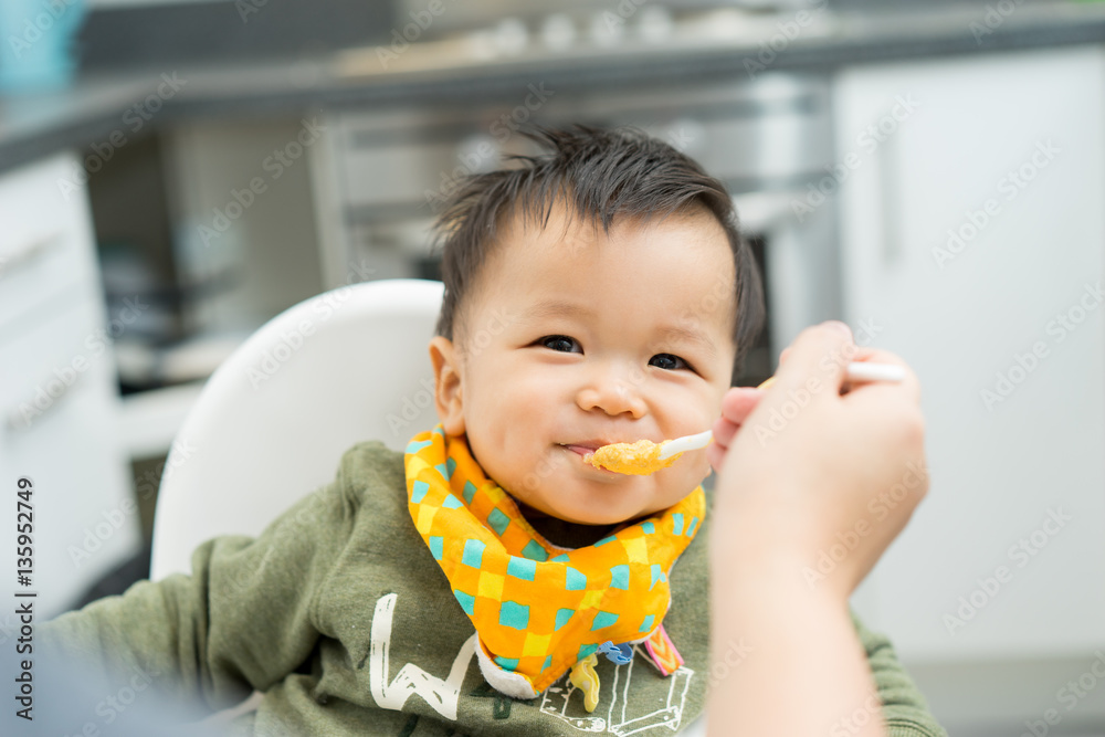 Asian baby boy eating blend food on a high chair - obrazy, fototapety, plakaty 