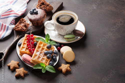 Coffee, sweets and waffles with berries