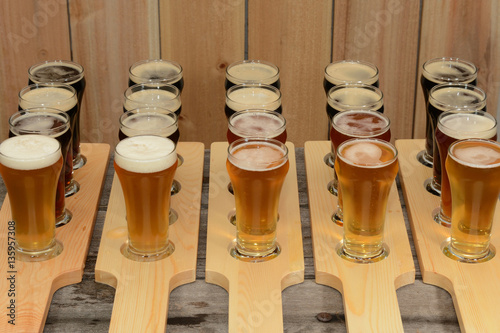 Beer flight sample showing variety of beer with paddle on rustic wooden table