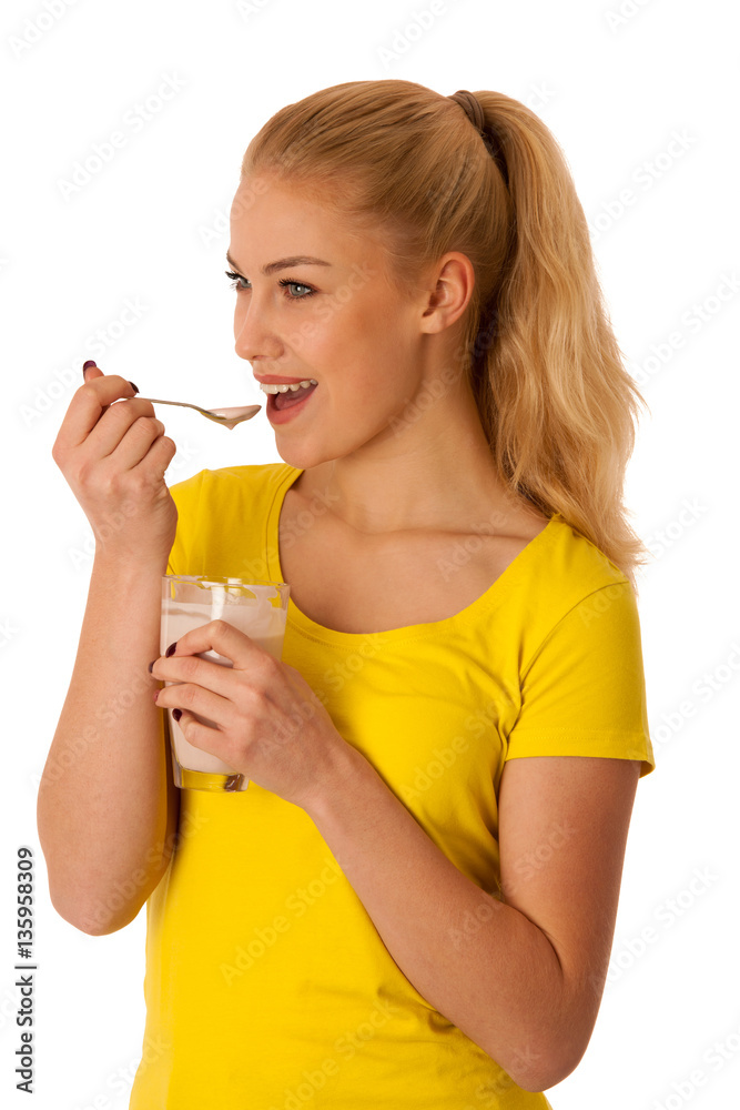 Cute blonde woman eating fruit yogurt isolated over white backgr Cute blonde woman eating fruit yogurt isolated over white backgr