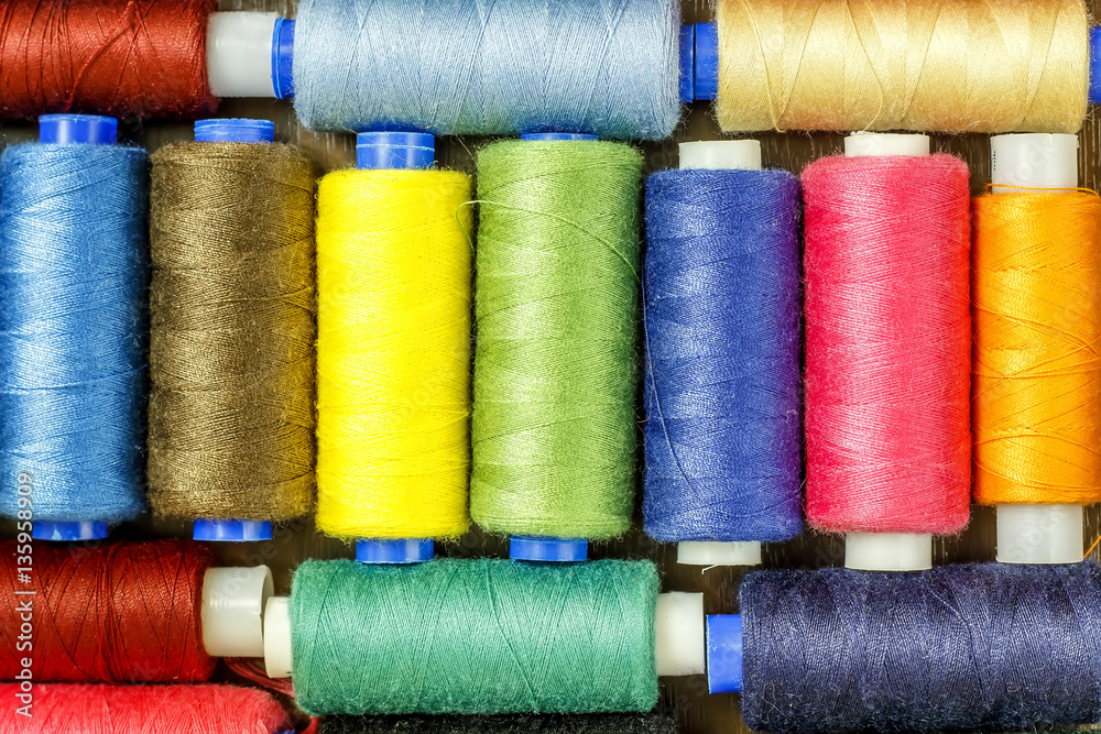Bobbins with colorful threads on old wooden table background, Sewing background Bobbins with colorful threads on old wooden table background, Sewing background