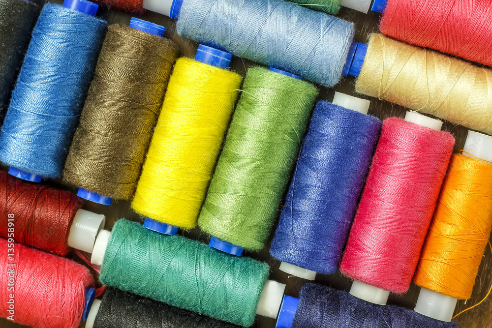 Bobbins with colorful threads on old wooden table background, Sewing background Bobbins with colorful threads on old wooden table background, Sewing background
