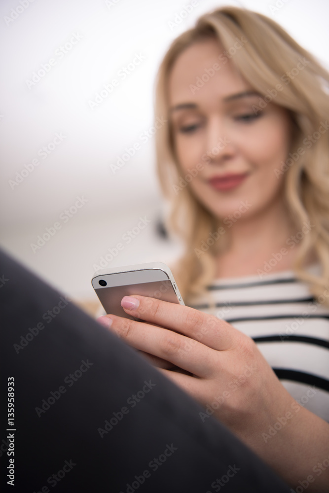 woman sitting on sofa with mobile phone woman sitting on sofa with mobile phone