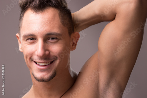 young man smiling face head closeup, arm raised up