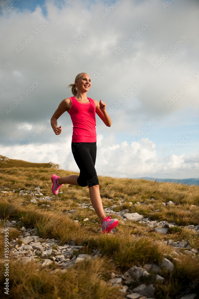 runner - woman runs cros country on a path in early autumn