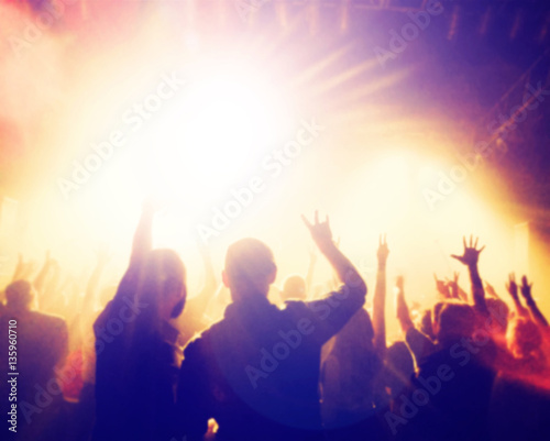  a crowd of people at a concert with a slight blur toned with a retro vintage filter