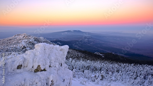Panoramic sunset sky in mountains with pine forest. Taganay national park in winter. Ural Mountains. photo