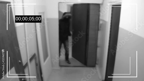 the young man in the mask breaks the door and tries to break the security camera