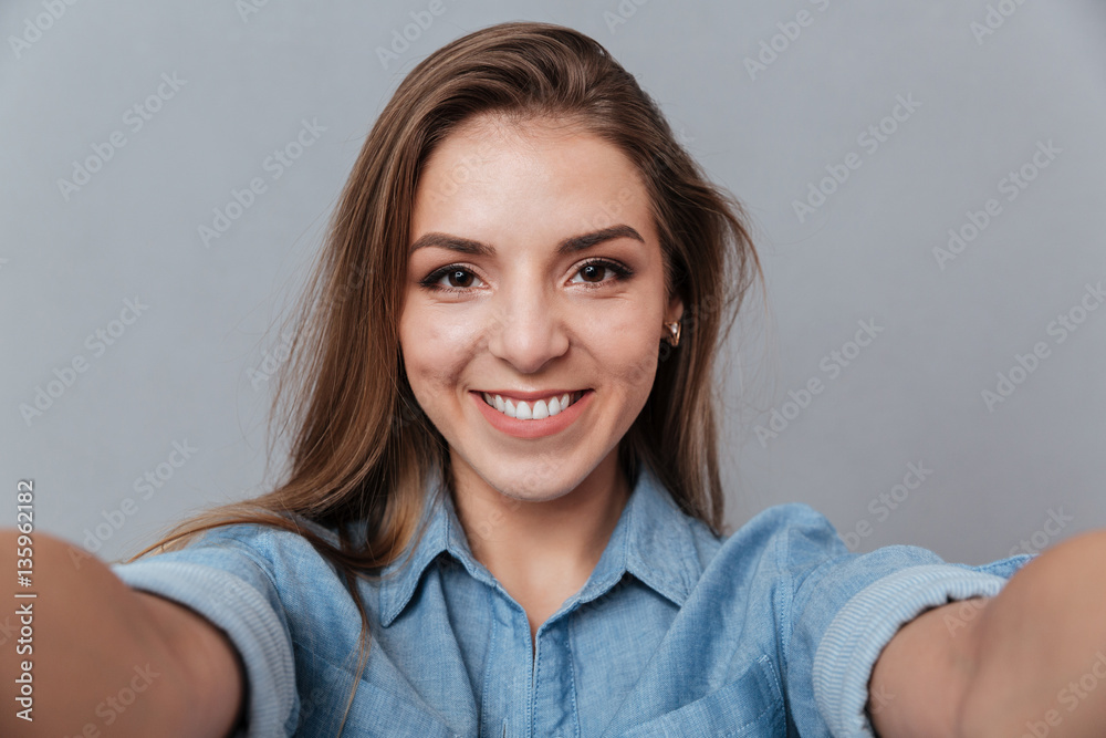 Smiling Woman in shirt making selfie in studio Smiling Woman in shirt making selfie in studio