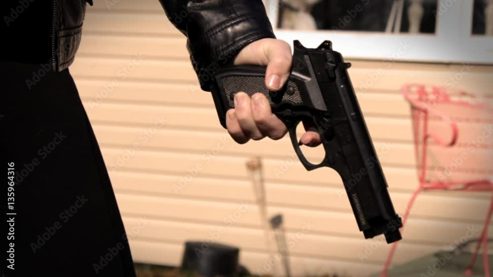 Female Secret Agent discharges pistol into object off camera  