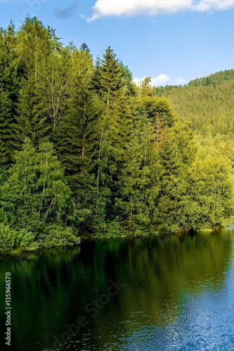 Mountain lake in clear weather, with the sky reflected in the water.