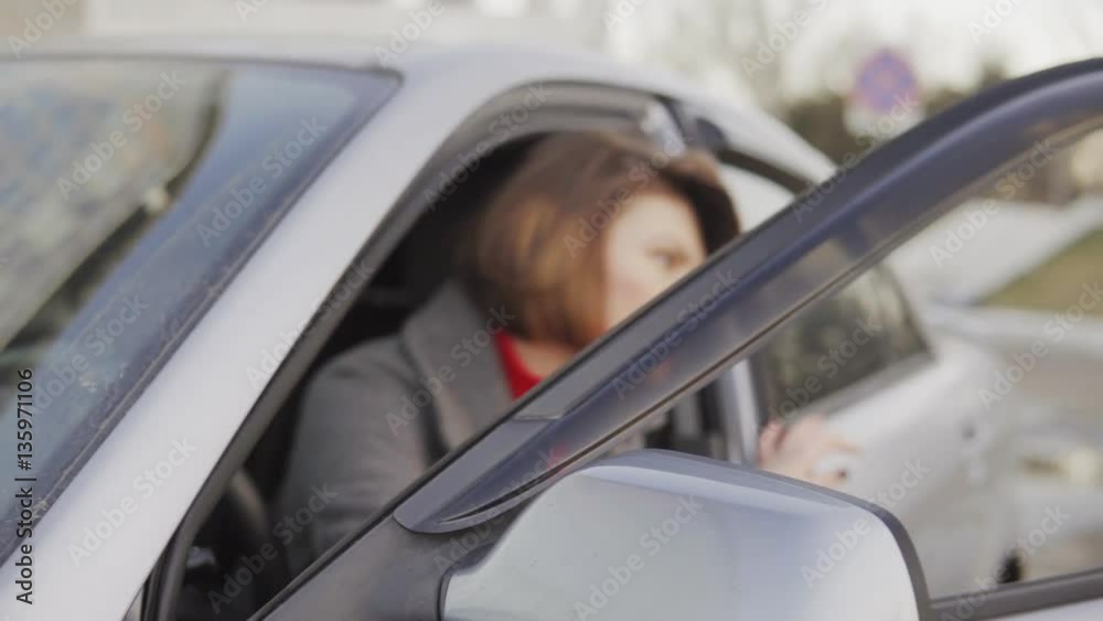 Closeup view of business woman in grey coat getting out of car