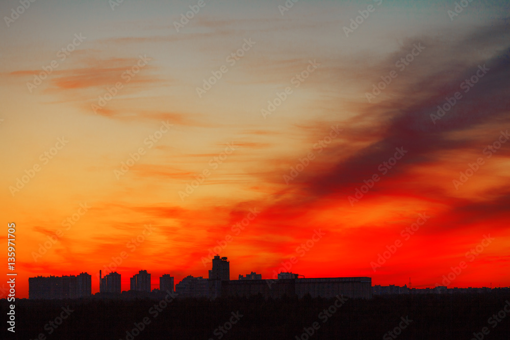 Sunrise in city landscape. Urban sunset. Rays of the sun above t