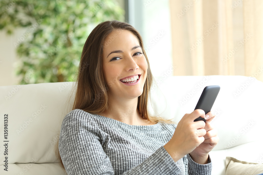 Happy girl holding phone and looking at camera Happy girl holding phone and looking at camera