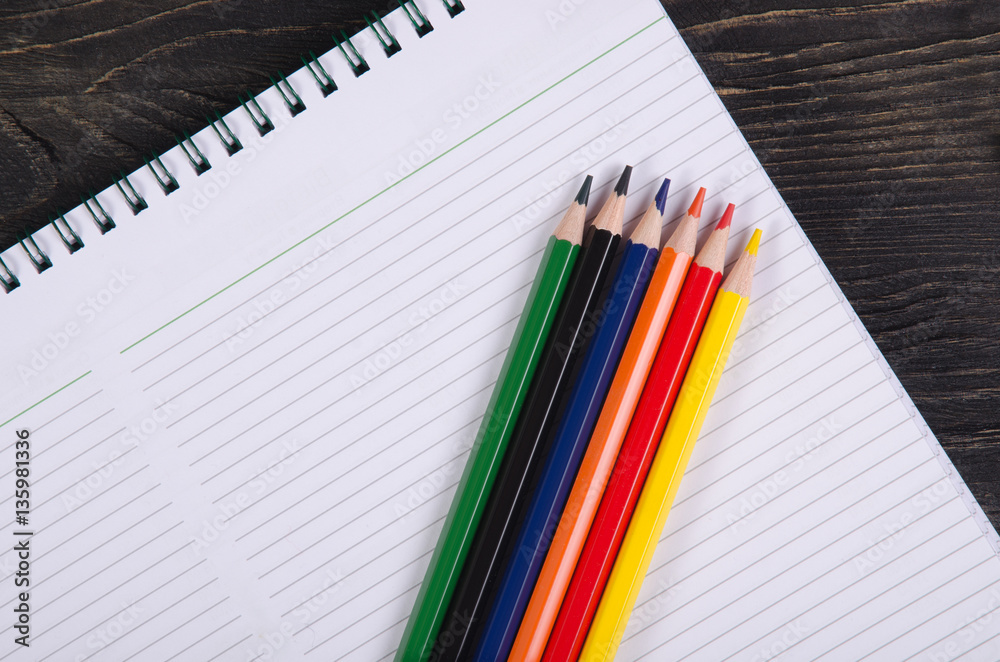 Colored pencils and a notebook Colored pencils and a notebook