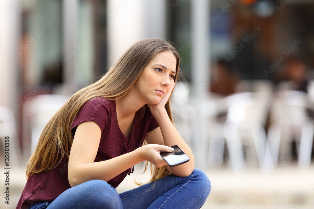 Sad girl waiting for a mobile phone call