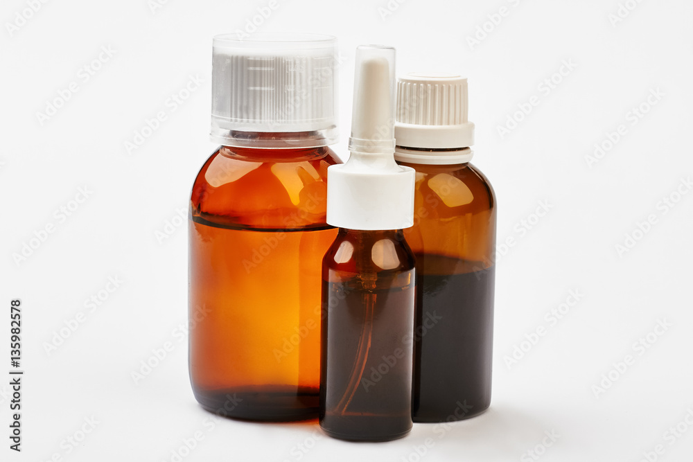 Liquid remedy in bottles. Cough syrup near nasal spray. Development of medicine.