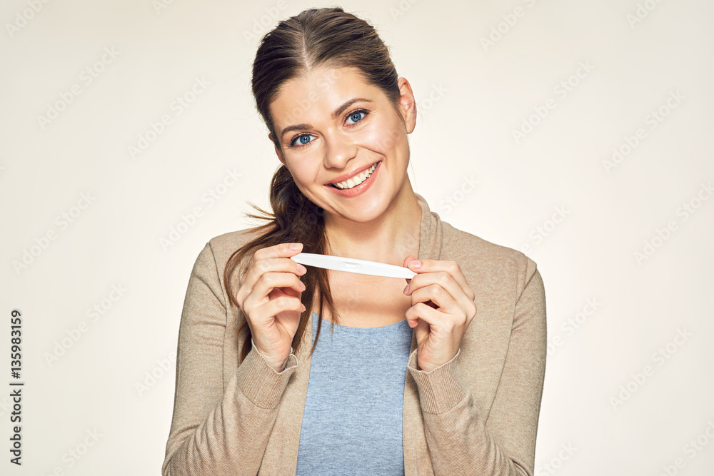 Isolated portrait of smiling young woman holding pregnant test. Isolated portrait of smiling young woman holding pregnant test.