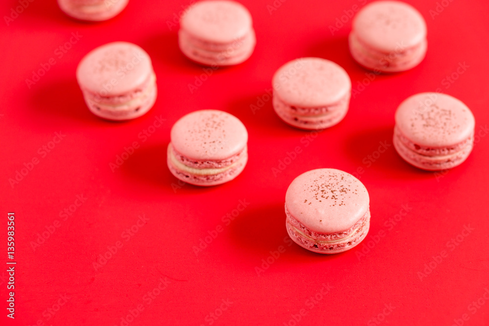 Macarons on a red background. These romantic french pastries are made of two meringue cookies and a sweet strawberry filling. Light & crisp, these macaroons are the perfect valentine day dessert. Macarons on a red background. These romantic french pastries are made of two meringue cookies and a sweet strawberry filling. Light & crisp, these macaroons are the perfect valentine day dessert.